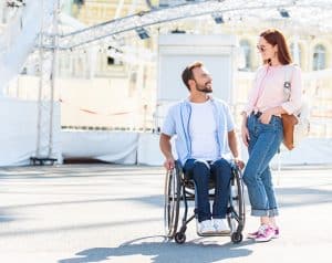 Couple at theme park man in wheelchair